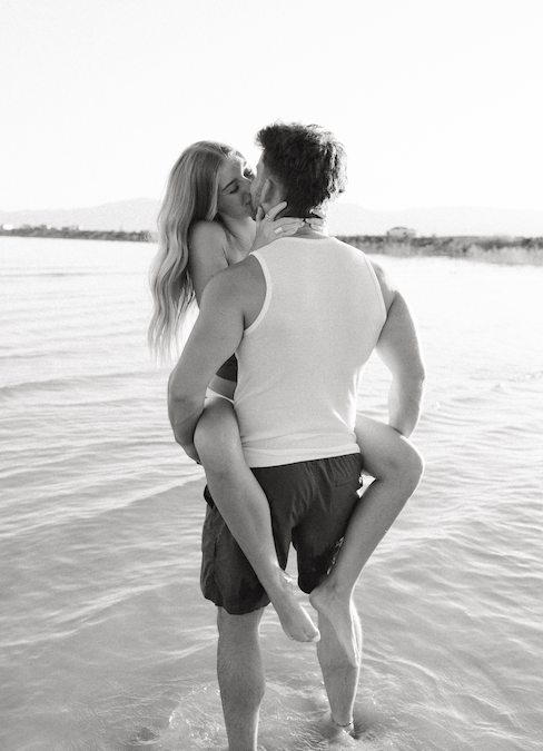 Guy kissing her neck while holding her waist