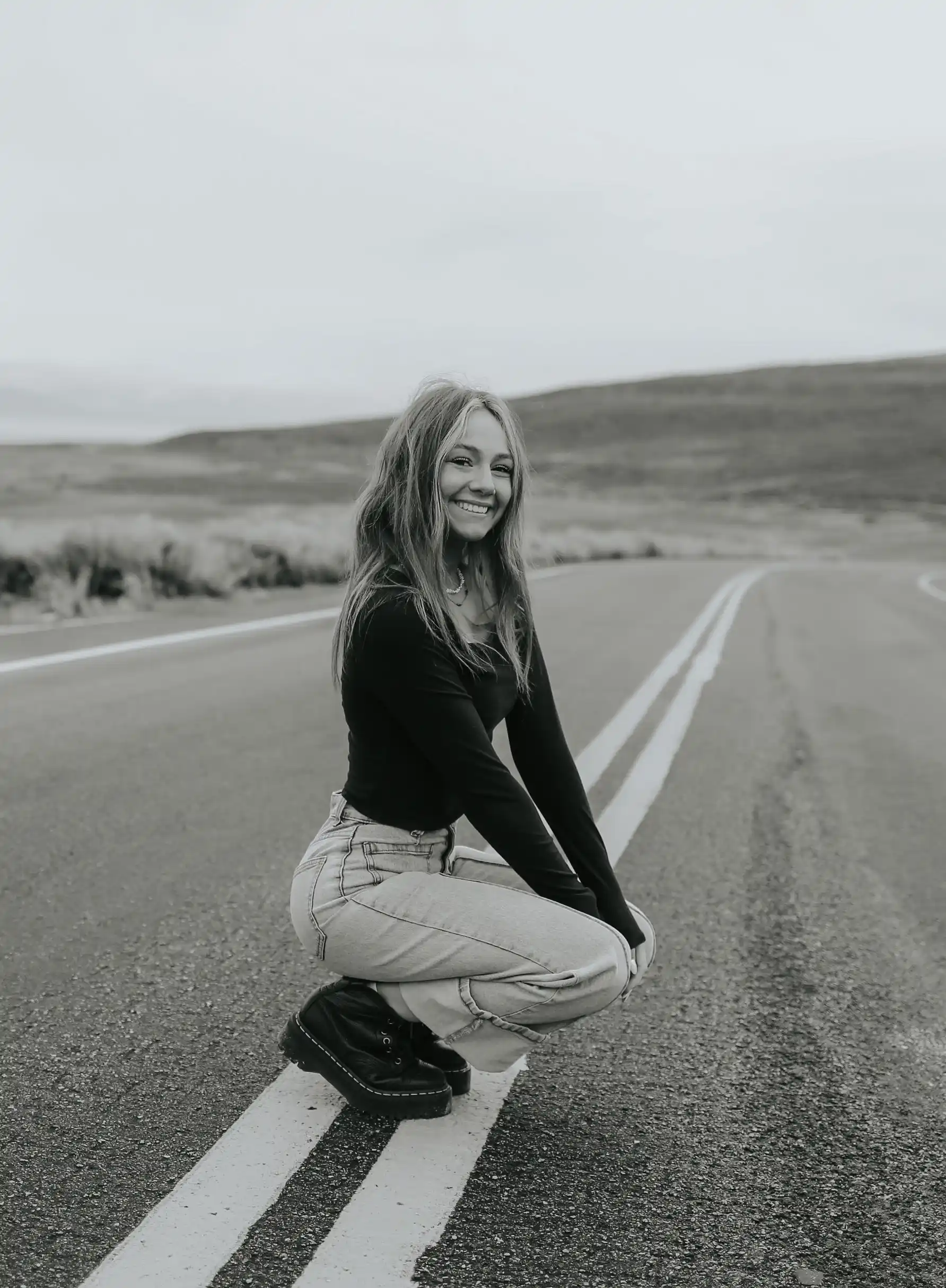 Girl squating and smiling in the road