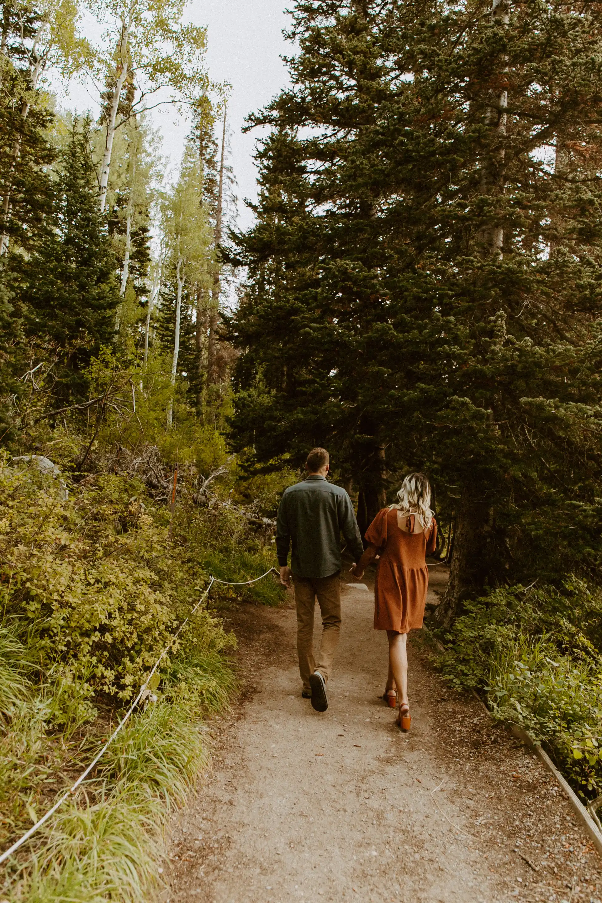 Couple walking down path holding hands